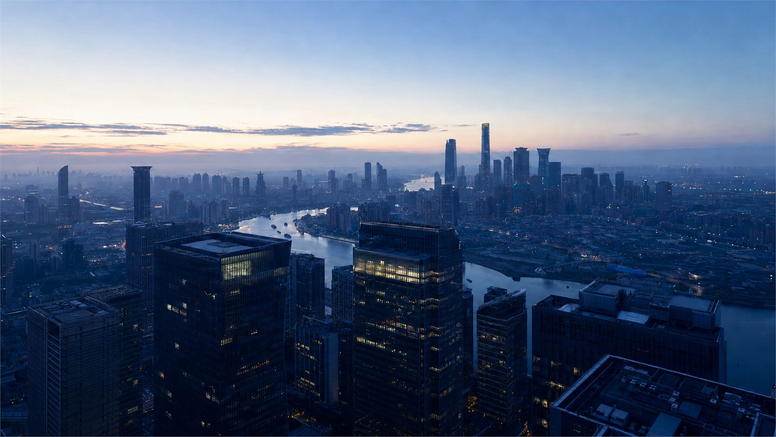 The Meridale financial district at dusk, seen from above with the river running through it.