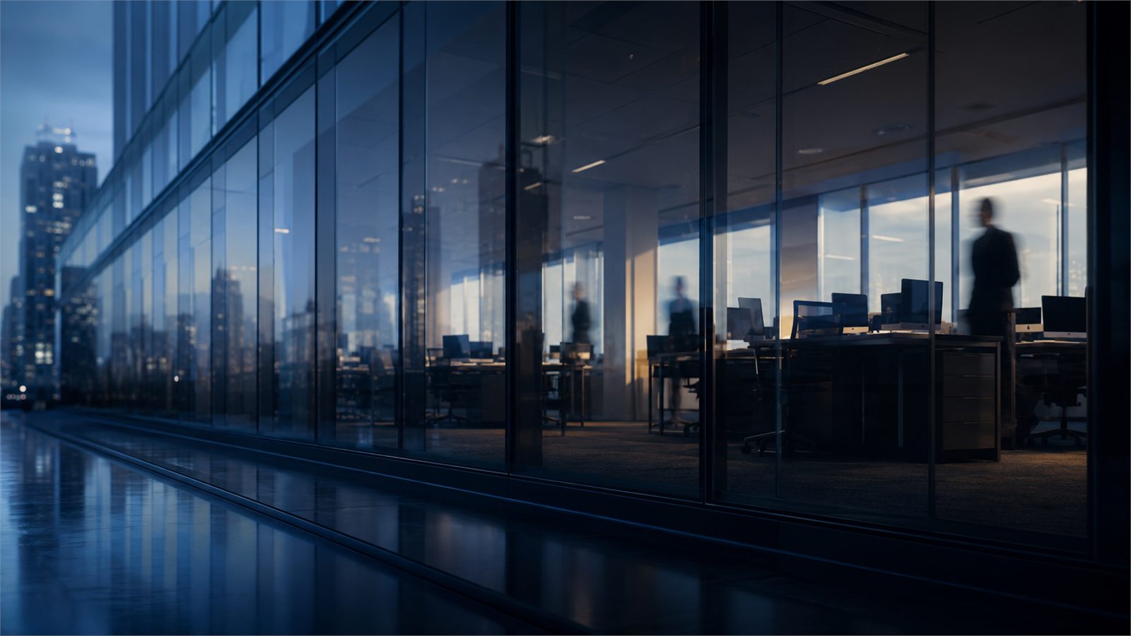 A glass office corridor photographed at blue hour.
